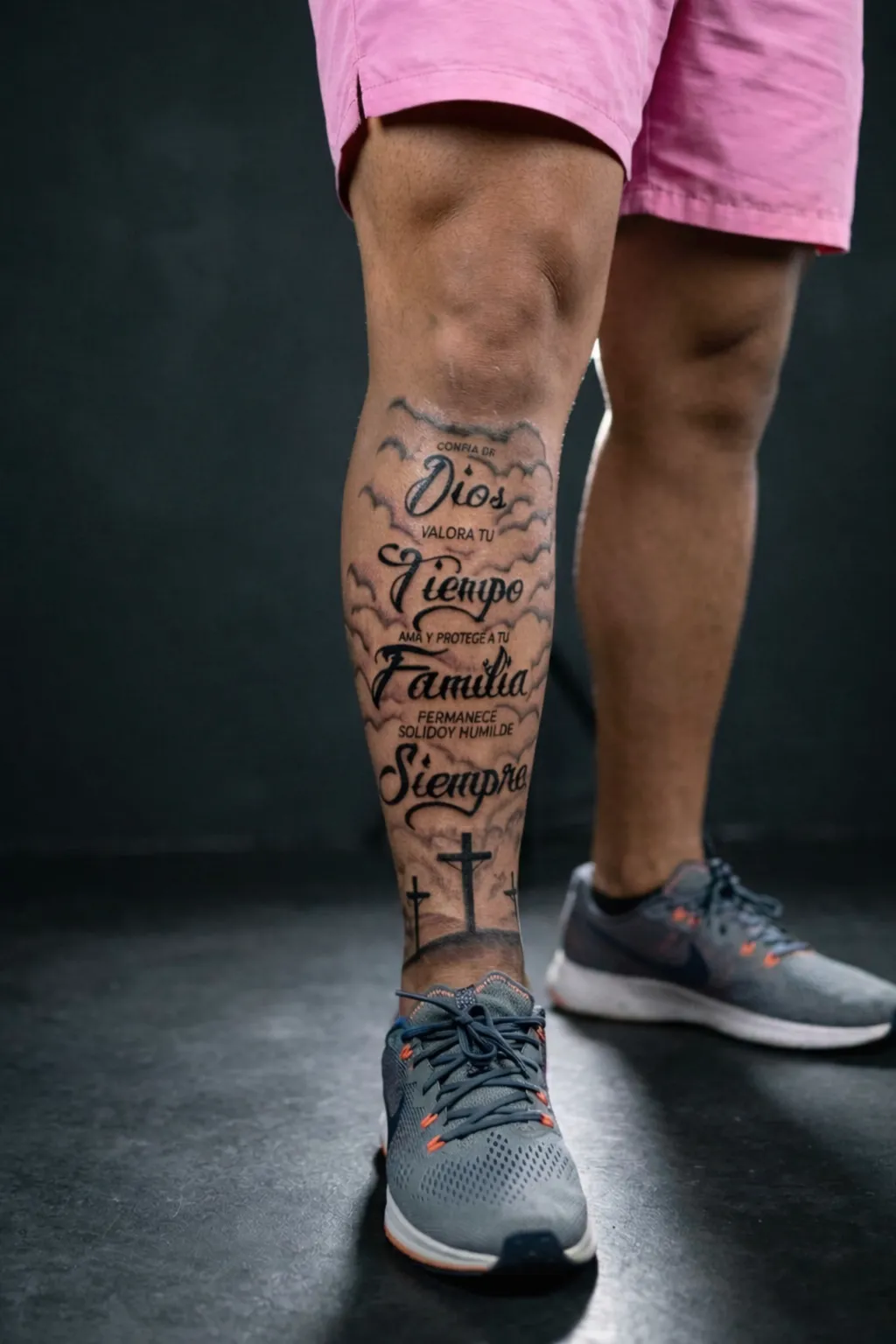 La misma pierna tatuada sobre un fondo de estudio limpio y oscuro con iluminación profesional uniforme — después de Beautique