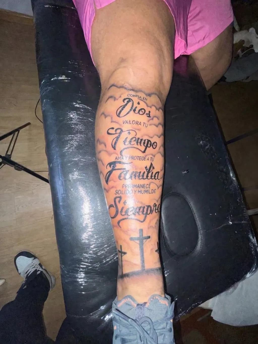 Pierna tatuada fotografiada en un estudio de tatuaje con fondo desordenado e iluminación irregular — antes de Beautique